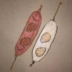 two beaded purses sitting next to each other on top of a white surface