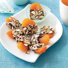 some oranges and nuts on a white plate