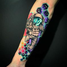 an astronaut tattoo on the right arm and leg, with hexagons in the background