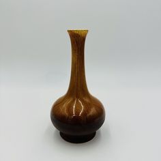 a brown vase sitting on top of a white table