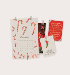 a calendar with candy canes on it next to two christmas cards and a red envelope