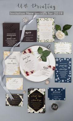 the wedding stationery is laid out with flowers and leaves on it, along with other items