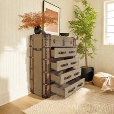 an old suitcase is stacked on top of a dresser in the corner of a room