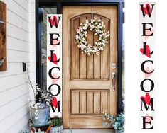 a welcome sign is on the front door of a house with a wreath and potted plants