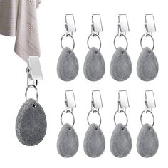 six pairs of silver metal hooks hanging from hooks