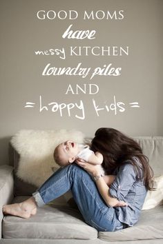 a woman sitting on top of a couch holding a baby in her lap and the words'good moms have messy kitchen, laundry piles, and happy kids '