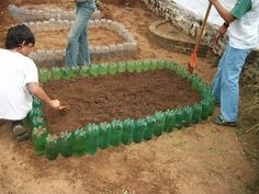 two men working in a garden made out of empty plastic bottles and dirt with shovels