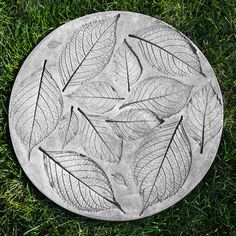 a cement plate with leaves on it in the grass