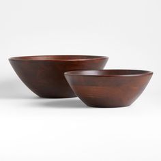 two wooden bowls sitting next to each other