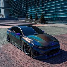 a car parked in front of a tall building on a brick road next to stairs