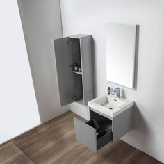 a white sink sitting under a bathroom mirror next to a wall mounted cabinet with an open door