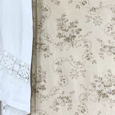 two white bedspreads are next to each other with floral designs and lace on them