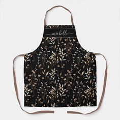 an apron with black and gold flowers on it, the words smellle are written in cursive writing