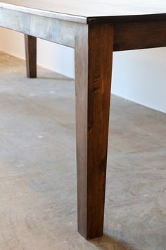 a wooden table sitting on top of a cement floor