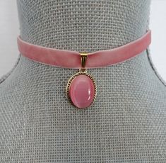 "Lovely pink velvet ribbon is threaded with a gold slider bail, linked with an oval gold and pink pearl cabochon focal.   The velvet ribbon closes at 13\" on first link and with the matching extension chain will adjust an additional 2\". There is a hook closure on the choker. The cabochon focal measures 3/4\" X 5/8\". All of my jewelry items come boxed, and ribbon tied and tagged for easy gifting." Pink Choker Necklace, Pink Velvet Ribbon, Pink Jewelry Box, Pink Choker, Velvet Choker Necklaces, Choker Necklace Designs, Ribbon Choker, Kawaii Jewelry, Gold And Pink