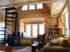 a living room filled with furniture and a fire place next to a loft type structure