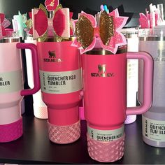 pink and white coffee mugs with bows on the handles are sitting next to each other