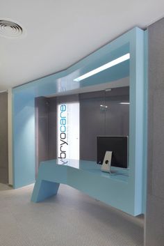 an empty office with a blue desk and computer monitor on the counter in front of it