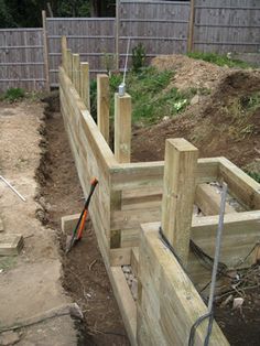 a wooden fence that is being built in the dirt