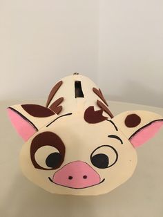 an animal mask with brown spots on it's face and ears, sitting on a table