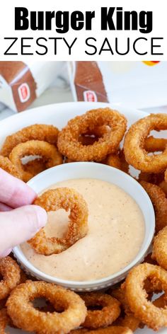 a plate with onion rings and dipping sauce on it, in front of the words burger king zesty sauce