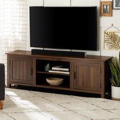 a flat screen tv sitting on top of a wooden entertainment center in a living room