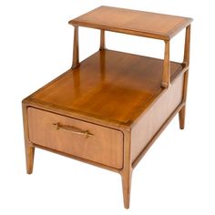 a small wooden table with two drawers on each side and one drawer at the top