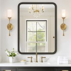 a bathroom sink with a large mirror above it and two lights on the wall next to it