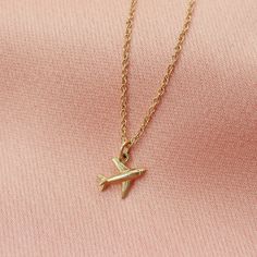 This little golden airplane necklace will have your heart soaring with joy! ✈️ Perfect for the adventurer in your life, its solid gold charm is sure to bring a smile to their face. Fly high in style with this little gold airplane charm necklace! The perfect everyday piece, made entirely of solid gold. DETAILS 10kt solid gold charm, cable chain and clasp Model wearing 18 inches long Charm measures 8mm across Check out our collection of fine jewelry, perfect for treating yourself!