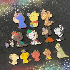 winnie the pooh and friends pin set on a black surface with glittery stars