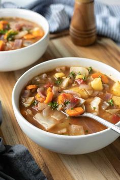 two bowls filled with soup on top of a wooden table