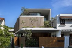 the house is surrounded by many trees and plants on both sides of the fenced in area