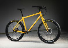 a yellow mountain bike with black spokes on the front and rear wheel rims