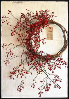 a wreath with red berries hanging on the wall