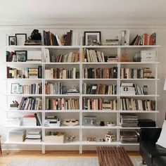 a living room filled with lots of furniture and bookshelves on top of each other