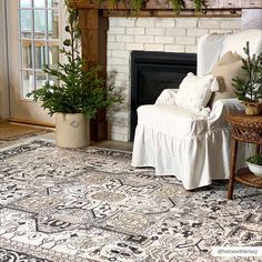 a living room filled with furniture and a fire place covered in christmas tree branches on top of a rug