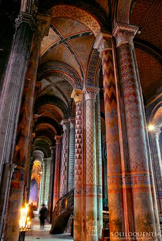 the inside of an old building with many pillars and arches, all painted in different colors