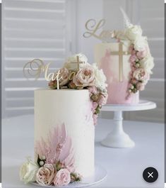 two wedding cakes decorated with pink and white flowers on top of each other, one has a cross