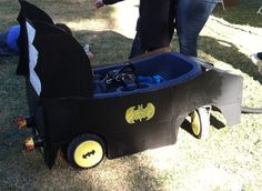 a child's costumed batman wagon is shown in the grass