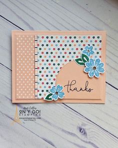 a thank card with blue flowers and polka dot paper on it, sitting on a wooden surface