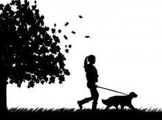 a woman walking her dog on a leash in the park silhouetted against a tree