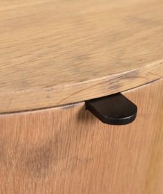 a close up of a wooden cabinet with a black handle