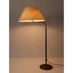 a floor lamp with a wooden shade on the base and a white light behind it