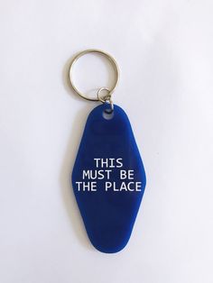 this must be the place keychain is blue with white letters on it and an oval metal ring