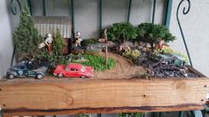 a wooden shelf filled with lots of toy cars and trees on top of it's sides