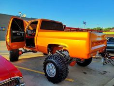 an orange pickup truck parked in a parking lot