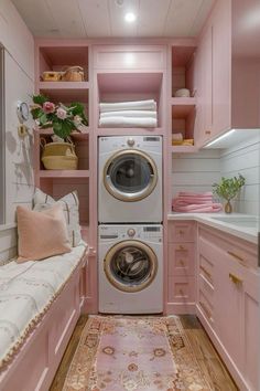 a washer and dryer in a pink laundry room with lots of storage space