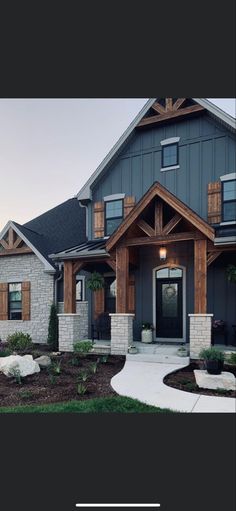 a large house with stone and wood trimmings on the front door, windows, and entry way