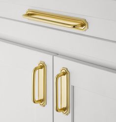 a close up view of the handles on a white cabinet with gold pulls and knobs