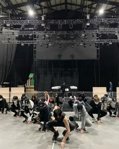 a group of people standing on top of a stage in front of a crowd with their hands together